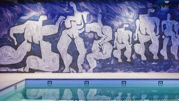 Ein Swimmingpool mit einem Mosaikbild an der Wand.