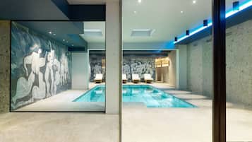 Een binnenzwembad en ligstoelen