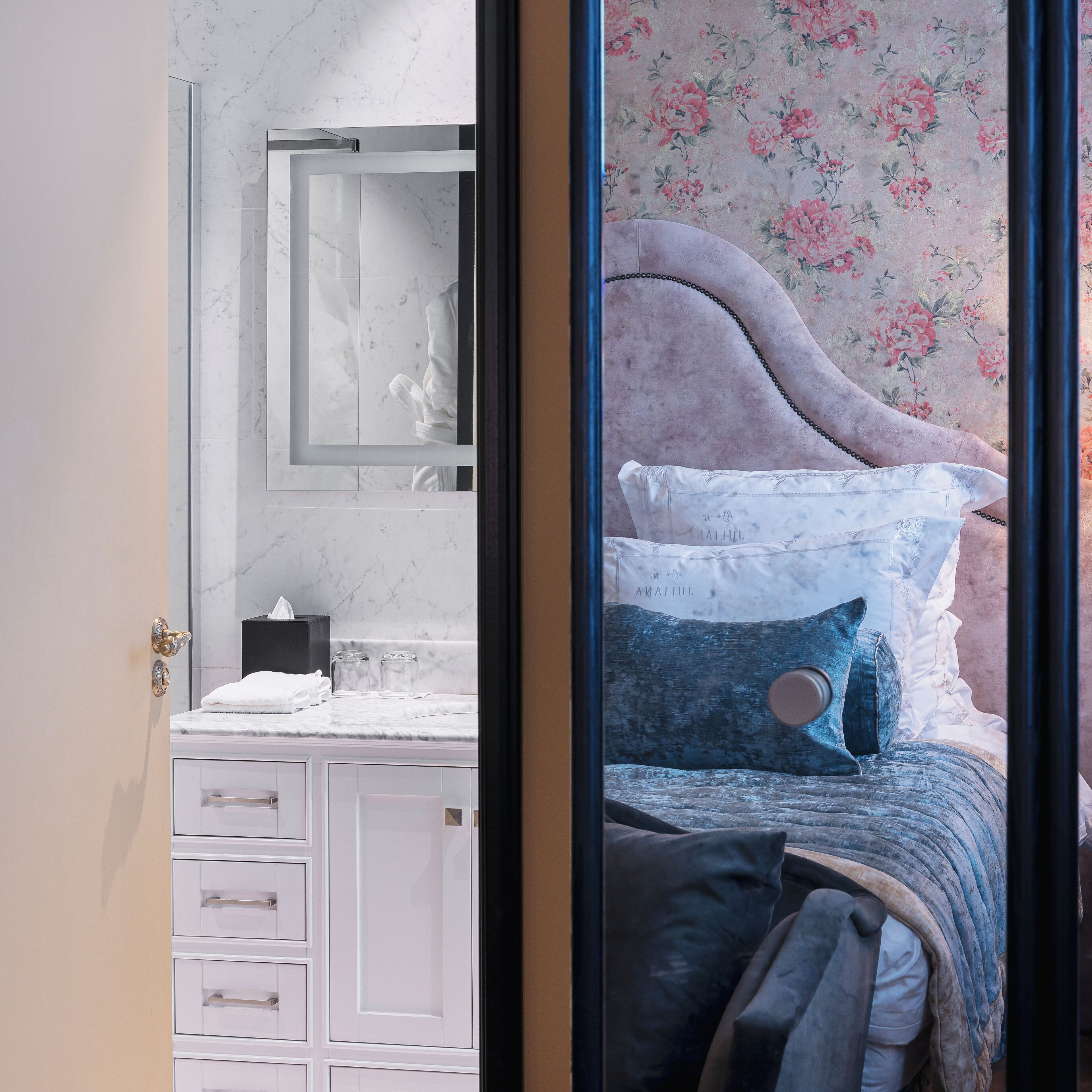 Une chambre à coucher avec un lit, une table de chevet, un miroir et une commode.