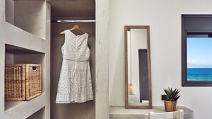 A room with a hanging dress, wicker baskets, a mirror, and a window with a view. - Sea Front LaMer Villa,Luxury Retreat & Heated Pool (Zakynthos)