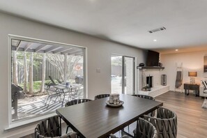 Een modern interieur met een eethoek, een open haard en grote ramen.