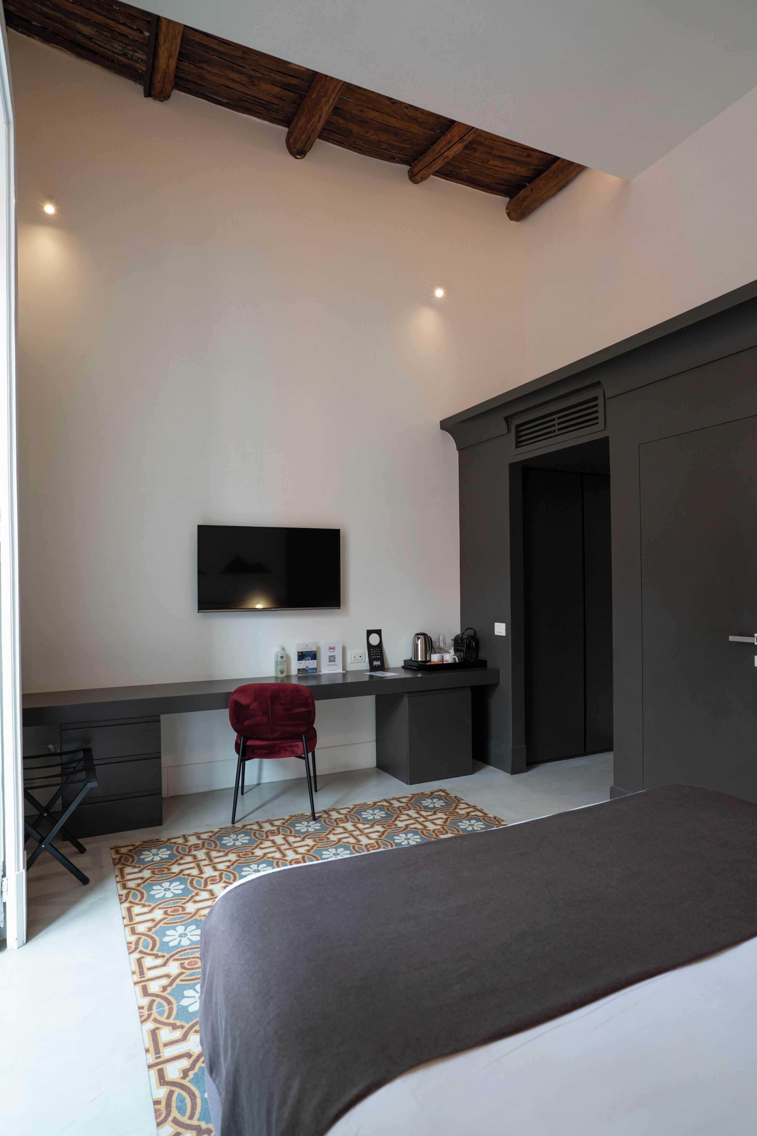 Une chambre à coucher comprenant un lit, un bureau avec une chaise, une télévision et une armoire.