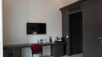 Une chambre à coucher comprenant un lit, un bureau avec une chaise, une télévision et une armoire.