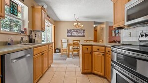 Una cocina con armarios de madera, un refrigerador de acero inoxidable, un microondas y una estufa grande.