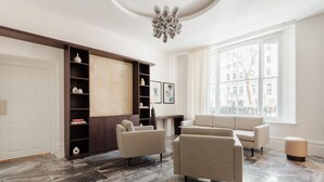 Un salón amplio con un ventanal grande, chimenea y una lámpara moderna.