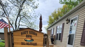 Une enseigne en bois indiquant « Randy's Rathbun Rental » avec un numéro de téléphone à contacter.