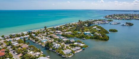 An aerial view of a coastal residential area with houses and docks.