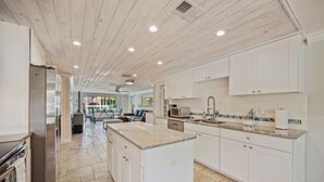 A spacious kitchen with white cabinets, granite countertops, and stainless steel appliances.
