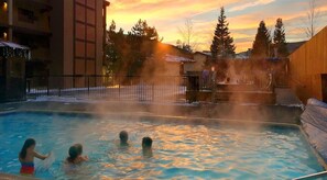 A hot tub area with a view of a building and trees in the background. - Newly Remodeled Condo Wren 201 with Creekside Views of Vail Mountain by RedAwning (Vail)