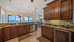 A spacious kitchen with wooden cabinets, a dishwasher, and a large island. - Bella Vista: Bay front with gorgeous views and outdoor living space. (Anna Maria)