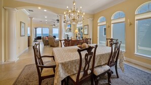A dining area with a chandelier, wooden chairs, and a table set for six. - Bella Vista: Bay front with gorgeous views and outdoor living space. (Anna Maria)