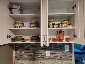 A kitchen with white cabinets, a tiled backsplash, and a granite countertop.