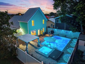 Ein Wohnhaus mit Swimmingpool, überdachter Terrasse und umzäunter Garten.