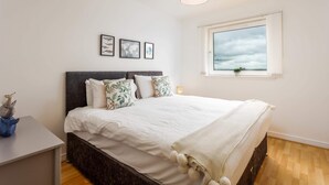 Una camera da letto con un letto, un comodino, una lampada e una finestra vista.