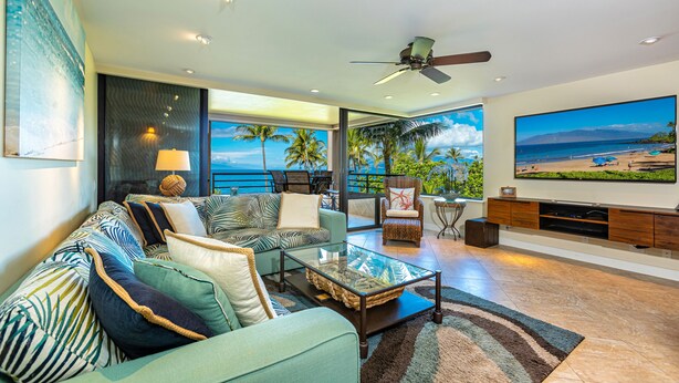 A modern living room with a large flat-screen TV, comfortable seating, and a view of the ocean. - Fabulous Ocean Views, Steps From Polo Beach, Luxury 2 Bed 2 Bath (Kihei)