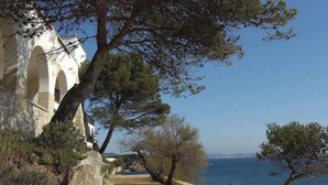Ein Küstenpfad mit einer Steinmauer und freiem Blick auf das Meer.