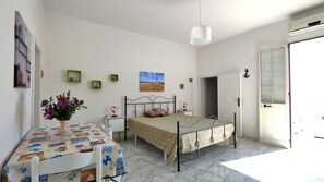 Ein Schlafzimmer mit Bett, Nachttisch, Lampe und einem Bild an der Wand.