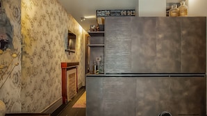 Una cucina moderna con carta da parati fantasia, un frigorifero integrato e una mensola decorativa.