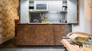 Una cucina compatta con forno a microonde integrato, un tostapane e un lavello.