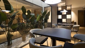 A modern meeting room with a glass partition, a large table, and comfortable chairs. - Goodnight Cádiz Apartments (Cádiz)