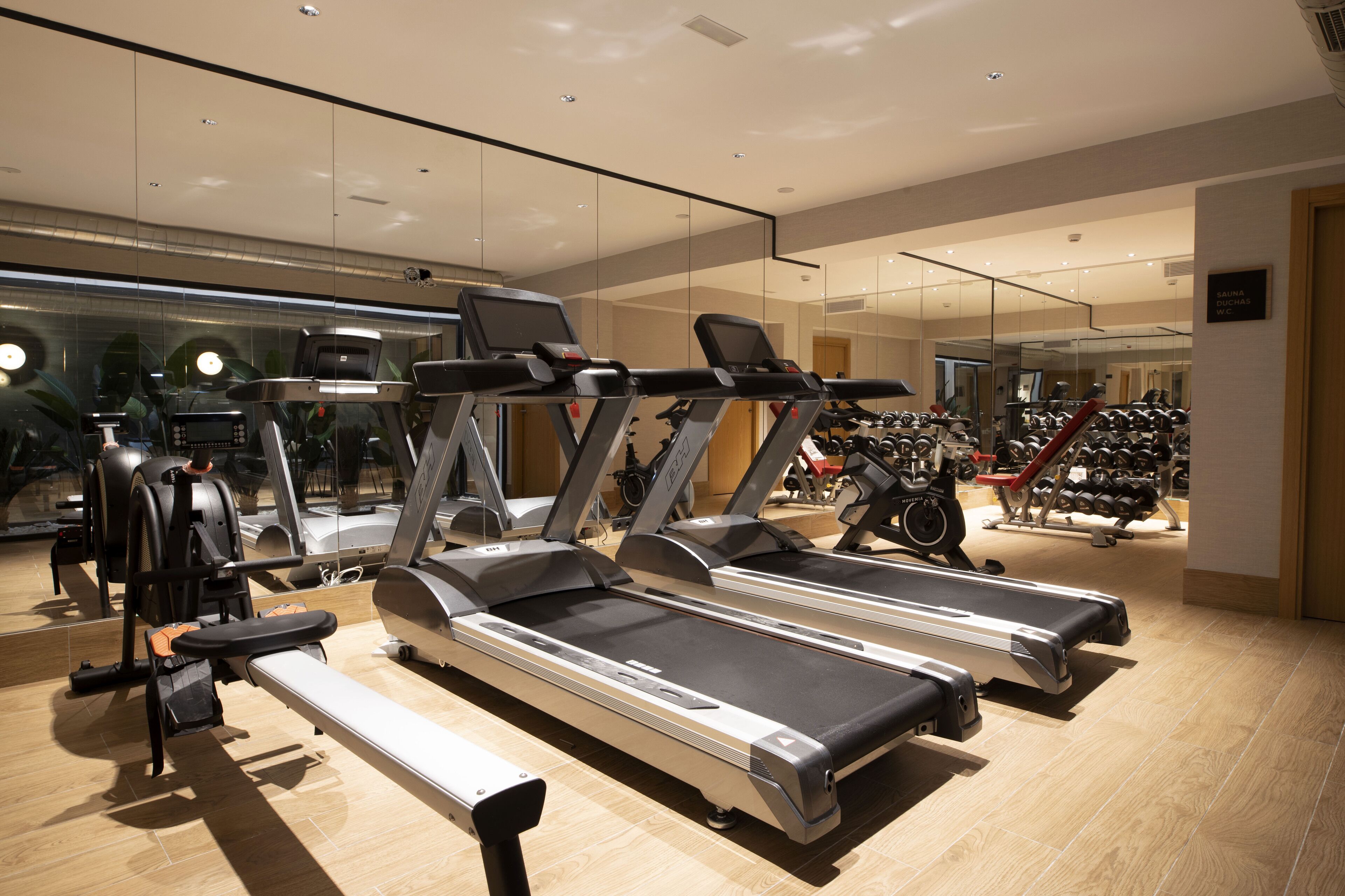A gym with treadmills, exercise bikes, and weight machines.