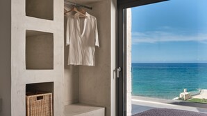 A bedroom with a large window overlooking the sea, a wardrobe with hanging clothes, and a wicker basket. - Sea Side LaLune Villa, with Heated Pool & Spa Whirlpool (Zakynthos)