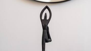 A black metal sculpture of a person in a yoga pose on a round table.
