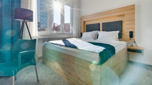 A modern hotel room with a wooden bed, a desk, and a chair. - Bed and Breakfast Sky (Zagreb)