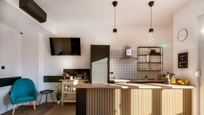 A modern kitchen with a central island, a built-in stove, and a hanging light fixture. - Bed and Breakfast Sky (Zagreb)