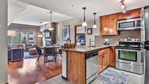A modern kitchen with stainless steel appliances, wooden cabinets, and a central island.