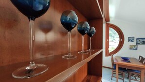A wooden shelf with wine glasses.