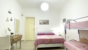 A bedroom with a bunk bed, a desk, and a chair. There is a door, a wall-mounted shelf, and a small rug on the floor. - Comodissimo Bilocale Dimora Raffaella (Torre Lapillo)