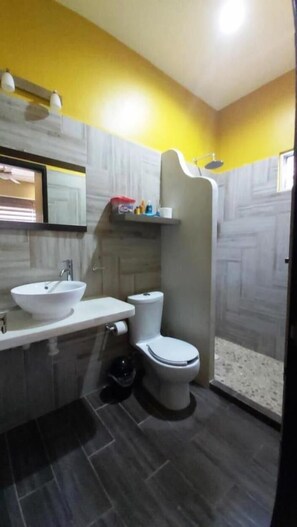 A bathroom with a white sink, toilet, and shower. - Beautiful upstairs apartment #3 (Tulum)