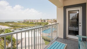 Un balcón con vistas a una piscina y una playa.
