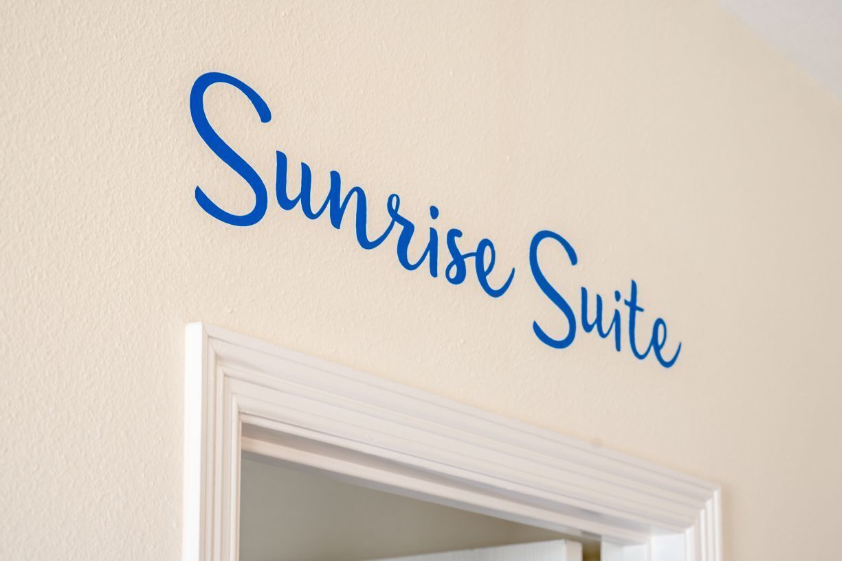 Eine Wand mit der Aufschrift "Sunrise Suite" in blauer Schrift.