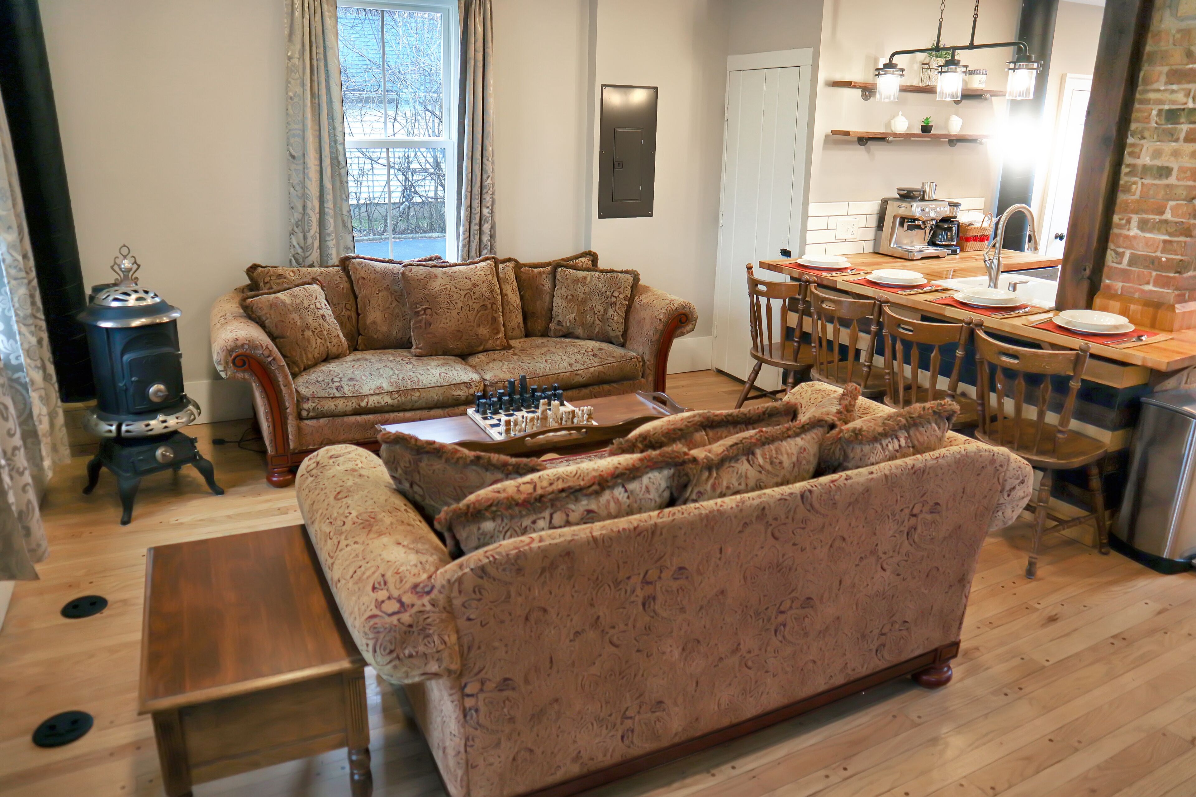 A cozy living room with a sofa, a wooden coffee table, and a fireplace.