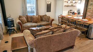 A cozy living room with a sofa, a wooden coffee table, and a fireplace.