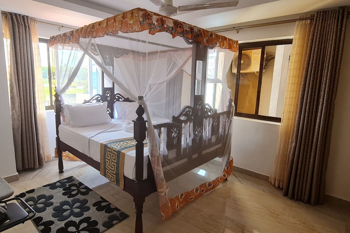 Un lit à baldaquin, une table de chevet et une chaise.