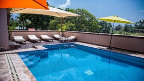 A swimming pool with lounge chairs and umbrellas. - The Festival Hotel Suites & Spa (Mtwapa)