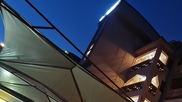 A multi-story building with a modern architectural design, featuring balconies with patterned railings and large windows. - The Festival Hotel Suites & Spa (Mtwapa)