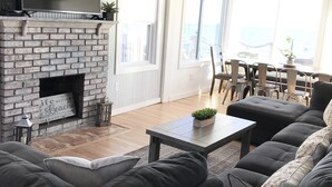 A living room with a fireplace, a sofa, a coffee table, and a TV. - Oceanfront Oasis Spacious 3-Bedroom, 2-Bath Retreat for 12  Linens Included (Old Saybrook)
