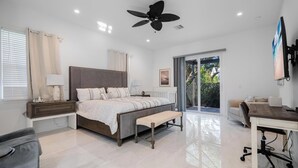 A modern bedroom with a large bed, a desk, and a bench. - Beautiful Naples Home with Private Pool Near Beach & Dining by Esthetic Stays (Naples)