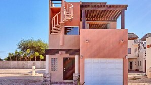A modern two-story house with a spiral staircase, a garage, and a small front porch. - Beautiful Sea of Cortes view Sandy Beach, Bella Vista (Puerto Peñasco)
