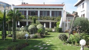 Un edificio de dos pisos con un jardín delantero.