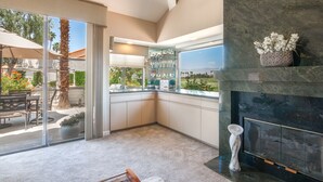 Una cocina moderna con puerta de cristal que da a un patio, una chimenea y vistas al exterior.