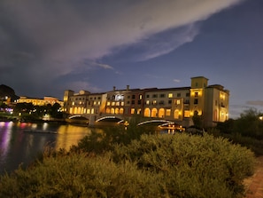 Stunning hotel with arched windows and balconies, overlooking a serene body of water.