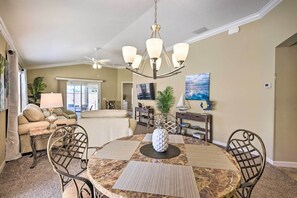 Relax in this inviting living room with a round coffee table, comfortable seating, and a large window offering a view of the outdoors.