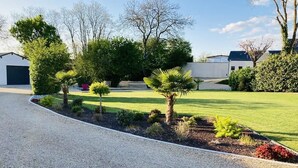 Une allée résidentielle bien entretenue, avec un chemin de gravier menant à une maison.