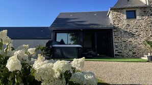 Une maison moderne avec une façade en pierre, une grande fenêtre et un espace patio.