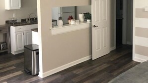A modern kitchen with white cabinets, a stainless steel refrigerator, and a countertop with a sink. - Adventure Acres- Suite B8  (Holly)